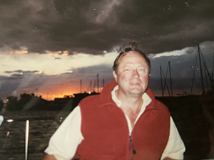Tom sailing at sunset wearing a fleece vest